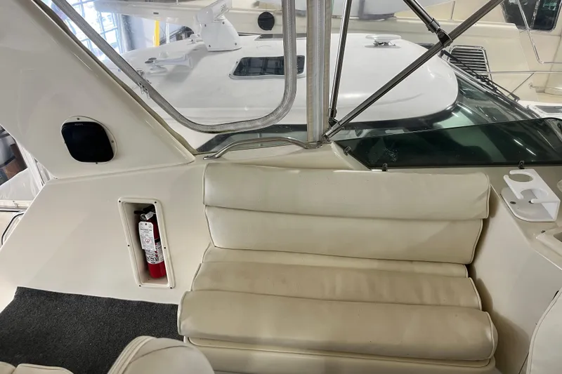Slide: The Image of Interior view of a 1991 Hatteras 40 Double Cabin yacht with cushioned seating and a fire extinguisher. - 13