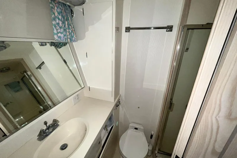 Slide: The Image of Bathroom interior of 1991 Hatteras 40 Double Cabin yacht, featuring sink, toilet, and shower. - 14