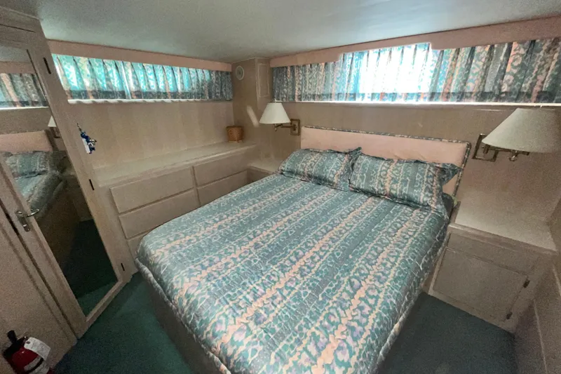 Slide: The Image of Cozy bedroom in 1991 Hatteras 40 Double Cabin yacht with patterned bedding and soft lighting. - 15