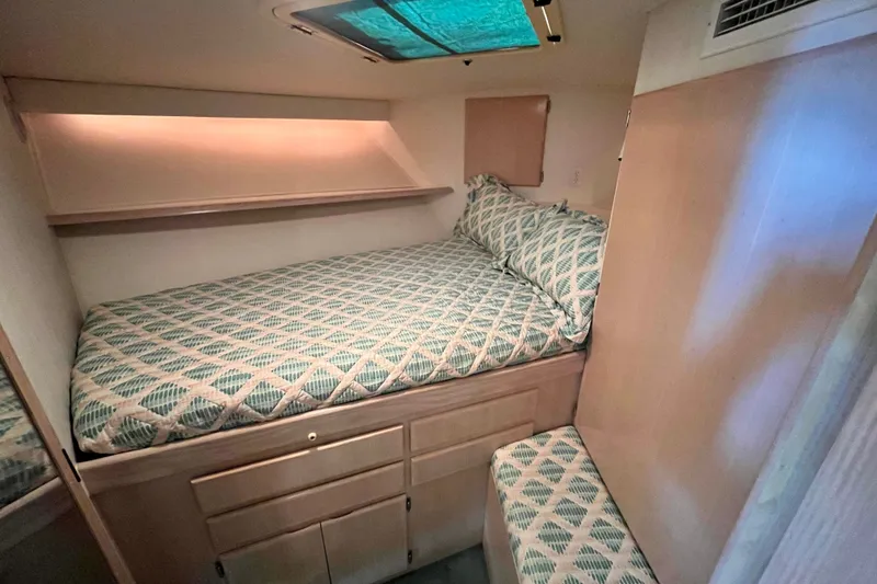 Slide: The Image of 1991 Hatteras 40 Double Cabin interior with cozy bed and patterned bedding. - 18