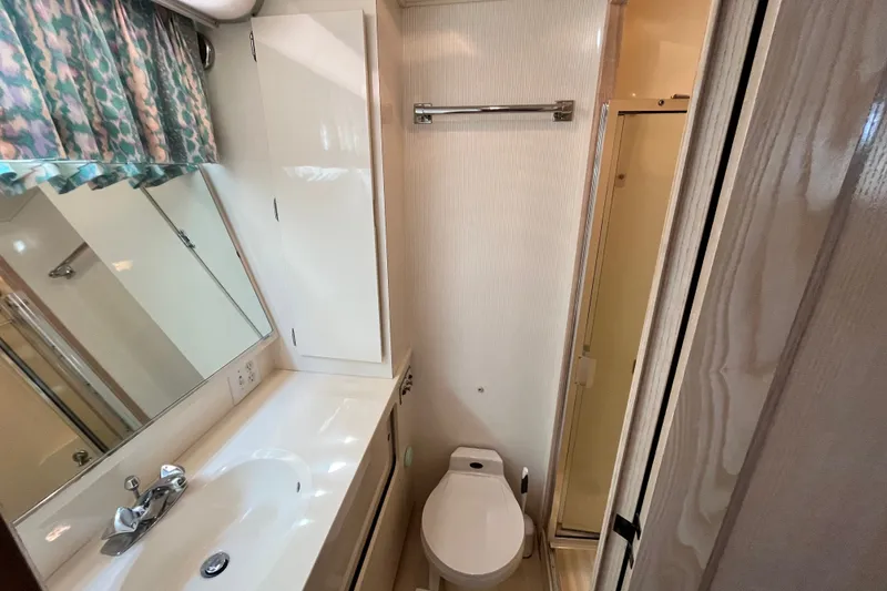 Slide: The Image of Bathroom interior of 1991 Hatteras 40 Double Cabin yacht, featuring sink, toilet, and shower. - 20