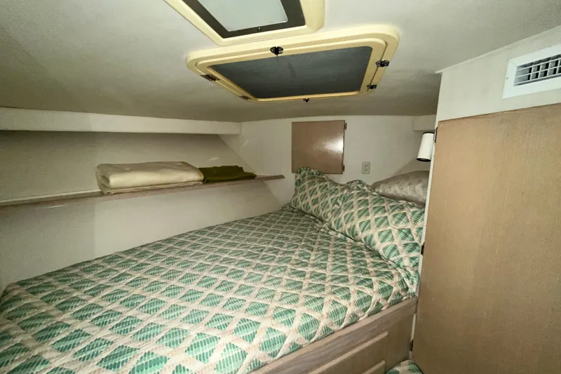 Slide: The Image of Cozy cabin interior of 1991 Hatteras 40 Double Cabin with patterned bedding and overhead hatch. - 7