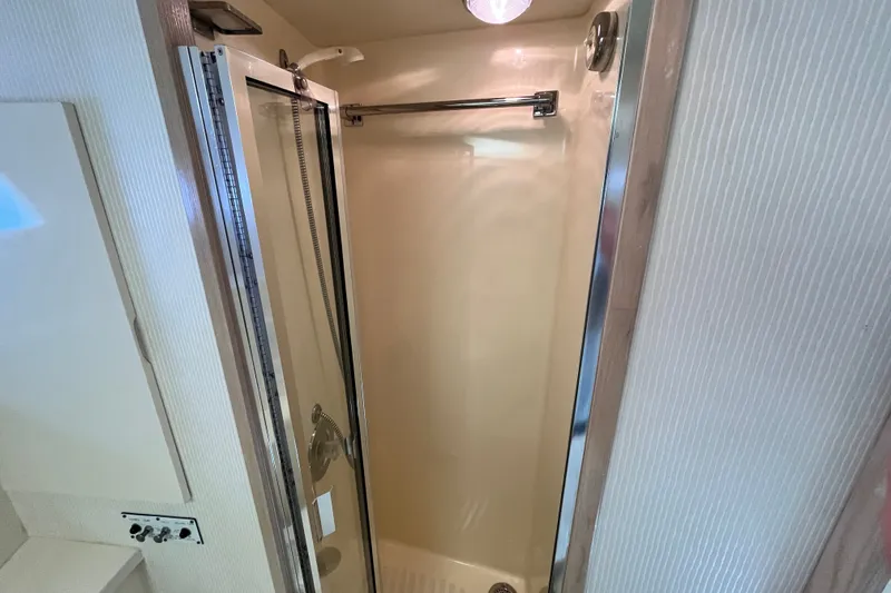 Slide: The Image of Shower area in 1991 Hatteras 40 Double Cabin yacht, featuring glass door and chrome fixtures. - 17