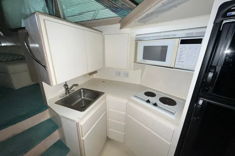 Slide: The Image of Compact kitchen in a 1991 Hatteras 40 Double Cabin yacht with stove and microwave. - 8