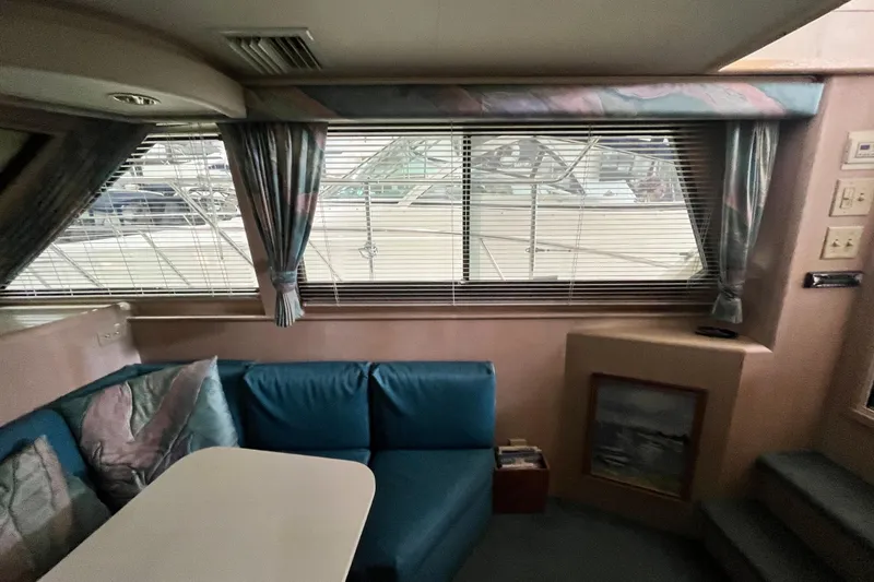 Slide: The Image of Interior of 1991 Hatteras 40 Double Cabin with blue seating and large windows. - 9