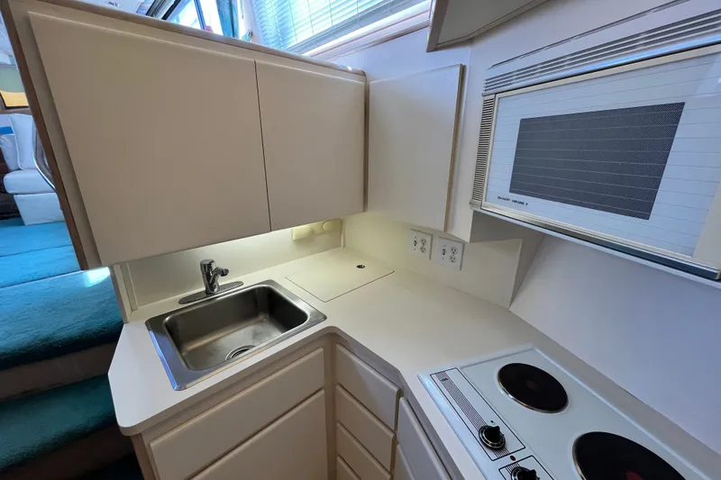 Slide: The Image of Compact kitchen in 1991 Hatteras 40 Double Cabin with sink, stove, and microwave. - 13