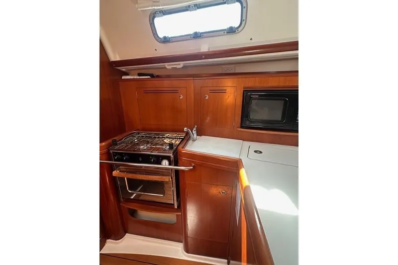 Slide: The Image of Galley kitchen in 2007 Beneteau 343 sailboat with stove, sink, and microwave. - 13