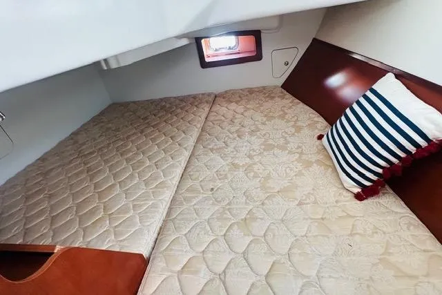 Slide: The Image of Cozy cabin interior of 2007 Beneteau 343 sailboat with striped pillow and window. - 19