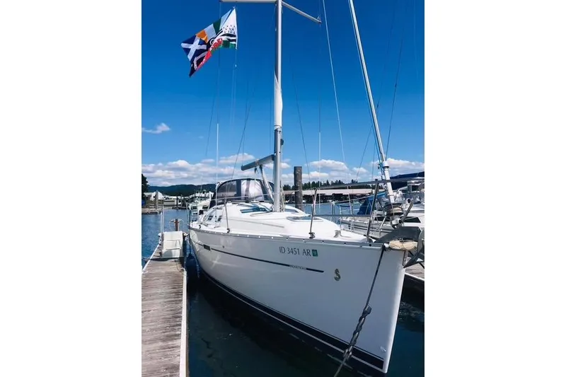 Slide: The Image of 2007 Beneteau 343 sailboat docked, displaying colorful flags under a clear blue sky. - 2