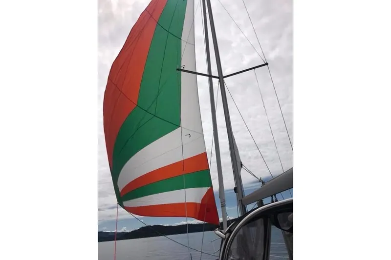 Slide: The Image of Sailing yacht Beneteau 343 (2007) with colorful spinnaker sail on a cloudy day. - 3