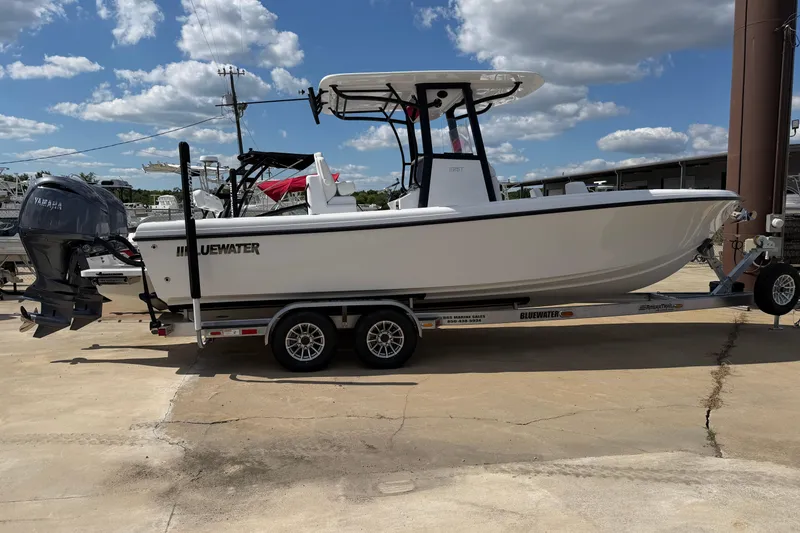 The Image of 2026 Bluewater Sportfishing 25T boat on trailer, featuring Yamaha outboard motor, under blue sky. - 1