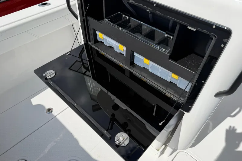Slide: The Image of Open storage compartment on 2026 Bluewater Sportfishing 25T boat, featuring organized tackle boxes. - 13