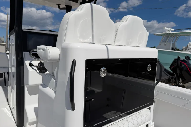 Slide: The Image of 2026 Bluewater Sportfishing 25T boat interior with white seating and steering console. - 15