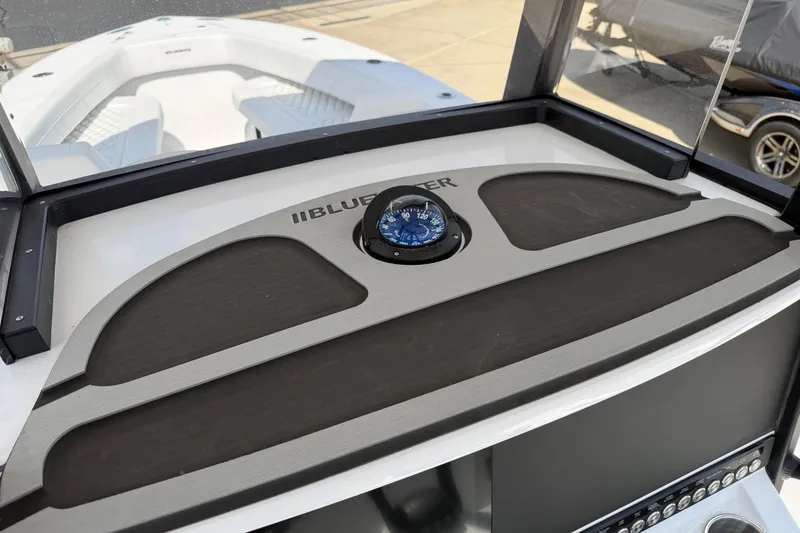 Slide: The Image of 2026 Bluewater Sportfishing 25T boat dashboard with compass and seating view. - 18
