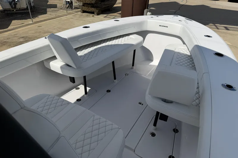 Slide: The Image of 2026 Bluewater Sportfishing 25T boat interior with white cushioned seating and sleek design. - 24