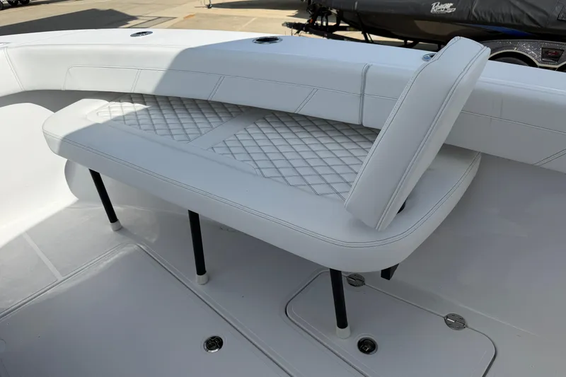 Slide: The Image of 2026 Bluewater Sportfishing 25T boat interior with white cushioned seating and diamond stitching. - 30