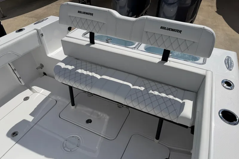 Slide: The Image of 2026 Bluewater Sportfishing 25T boat interior with white cushioned seating and storage compartments. - 31