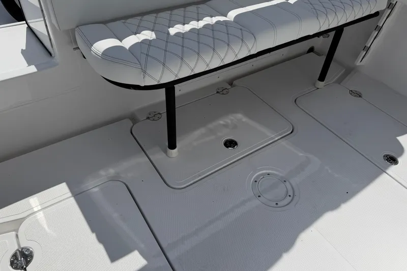 Slide: The Image of 2026 Bluewater Sportfishing 25T boat interior with cushioned seating and storage compartments. - 32