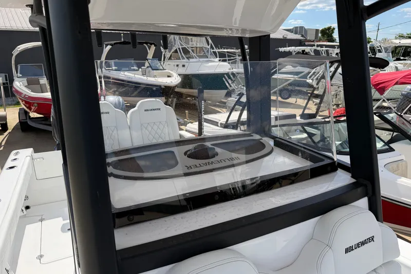 Slide: The Image of 2026 Bluewater Sportfishing 25T boat interior with seating and console, displayed outdoors. - 35