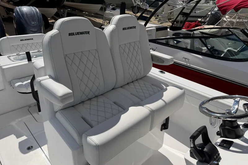 Slide: The Image of 2026 Bluewater Sportfishing 25T boat with luxurious white seating and steering wheel. - 37
