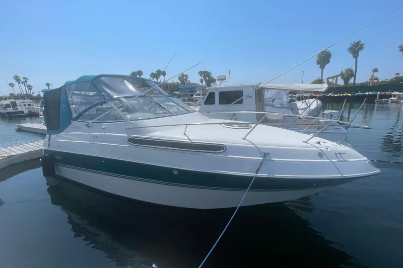 The Image of 1994 Four Winns 258 Vista boat docked in a marina under clear blue skies. - 0