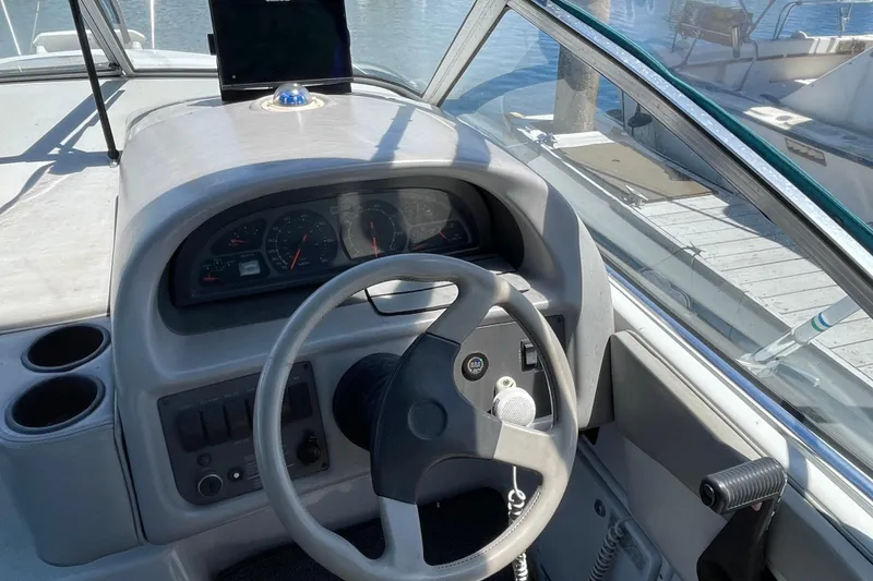 Slide: The Image of Steering console of a 1994 Four Winns 258 Vista boat, featuring gauges and controls. - 2