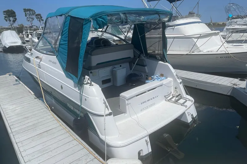 Slide: The Image of 1994 Four Winns 258 Vista boat docked at marina with blue canopy. - 3