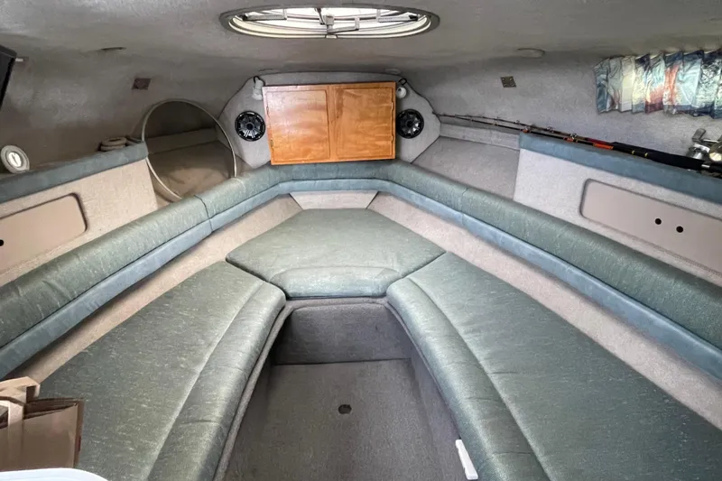 Slide: The Image of Interior of 1994 Four Winns 258 Vista boat with cushioned seating and storage. - 4