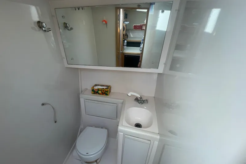 Slide: The Image of 1994 Four Winns 258 Vista boat bathroom with sink, mirror, and toilet. - 6