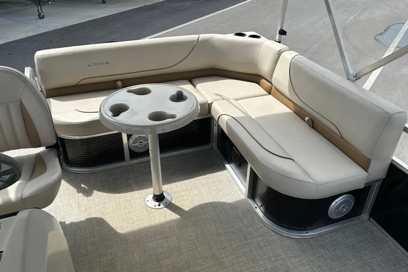 Slide: The Image of 2023 Lowe Ultra 162 Fish & Cruise boat interior with beige seating and cupholder table. - 10