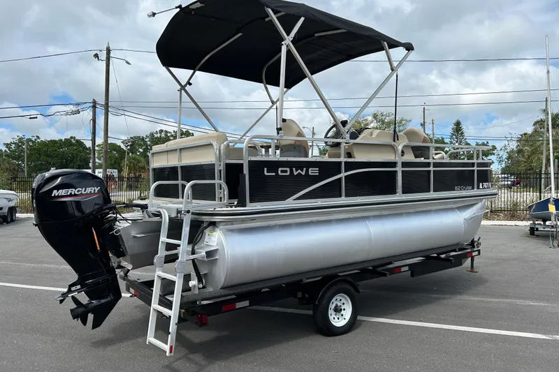 Slide: The Image of 2023 Lowe Ultra 162 Fish & Cruise pontoon boat with Mercury outboard motor on trailer. - 2