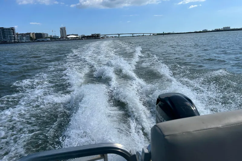 Slide: The Image of 2023 Lowe Ultra 162 Fish & Cruise boat cruising on open water, cityscape in background. - 20