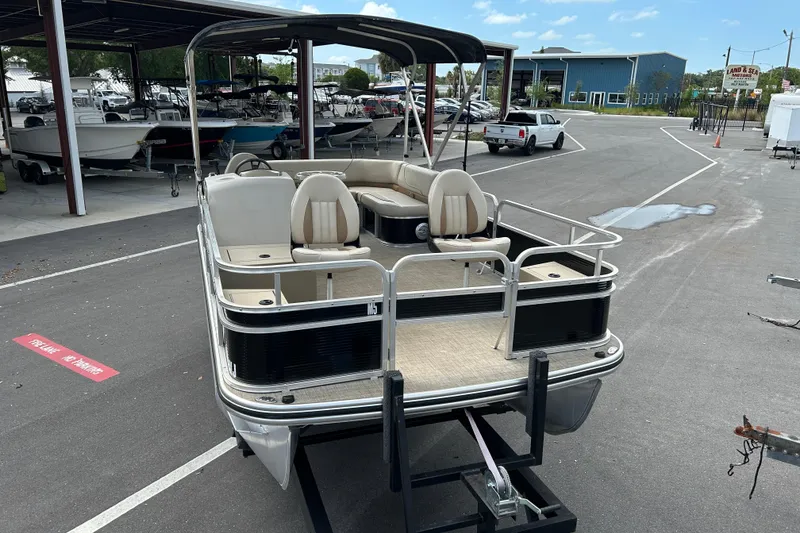 Slide: The Image of 2023 Lowe Ultra 162 Fish & Cruise pontoon boat on trailer in marina setting. - 7