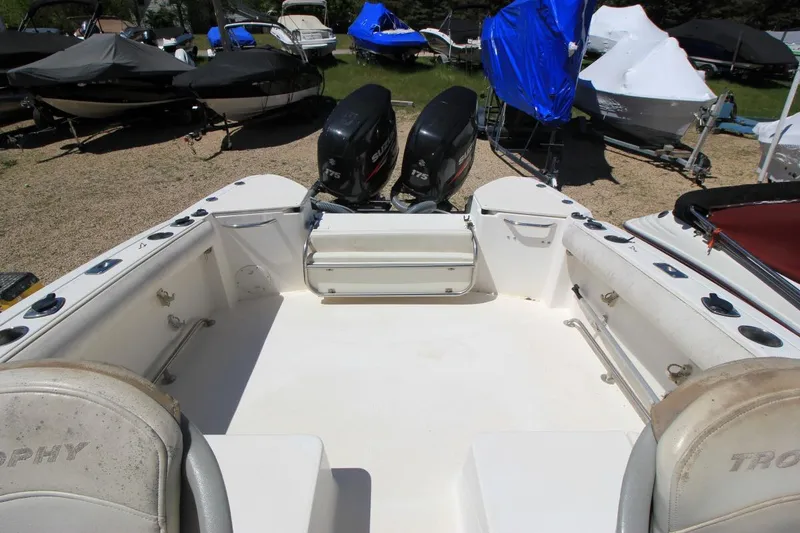 Slide: The Image of 2008 Trophy 2302 Walkaround boat with dual outboard motors in a storage yard. - 16
