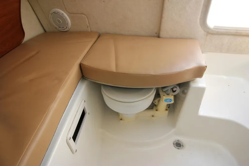 Slide: The Image of 2008 Trophy 2302 Walkaround cabin interior with cushioned seating and hidden toilet. - 19