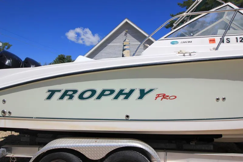 Slide: The Image of 2008 Trophy 2302 Walkaround boat side view with clear blue sky background. - 2