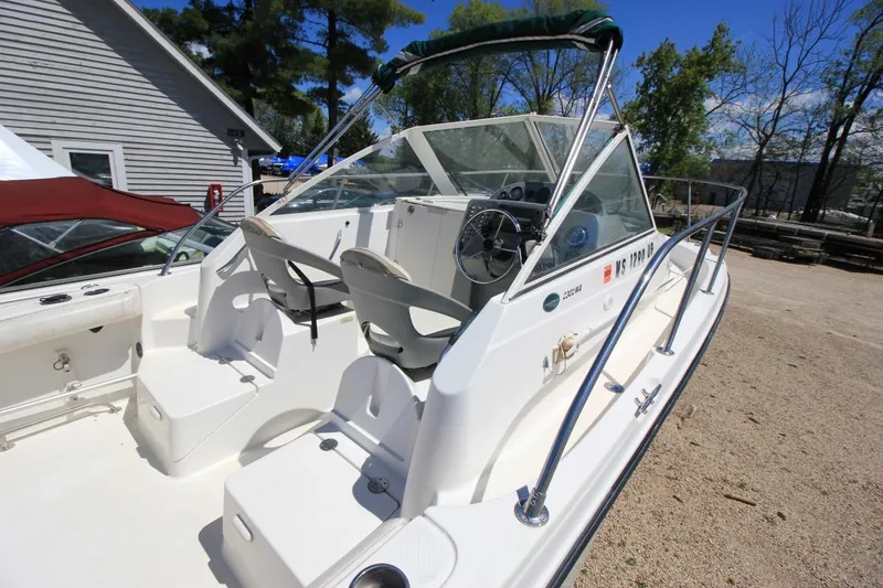 Slide: The Image of 2008 Trophy 2302 Walkaround boat with dual seats and steering wheel, docked outdoors. - 5