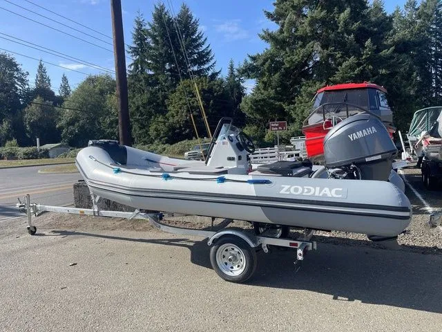 Slide: The Image of 2026 Zodiac Boats Open 4.2 on trailer, parked outdoors. - 2