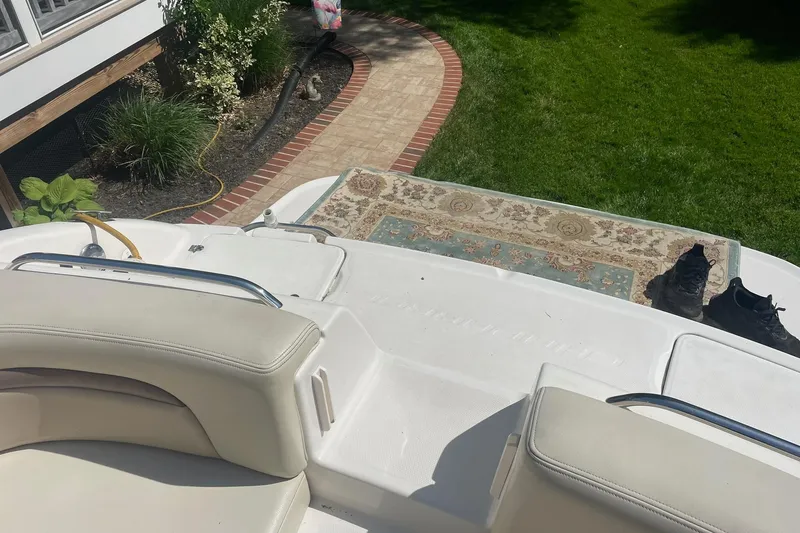 Slide: The Image of 2005 Chaparral 265 SSi boat interior with seating, rug, and shoes on deck. - 12