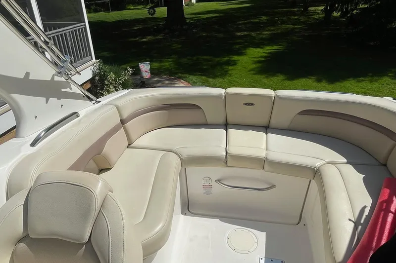 Slide: The Image of 2005 Chaparral 265 SSi boat interior with cream leather seating in a sunny outdoor setting. - 14