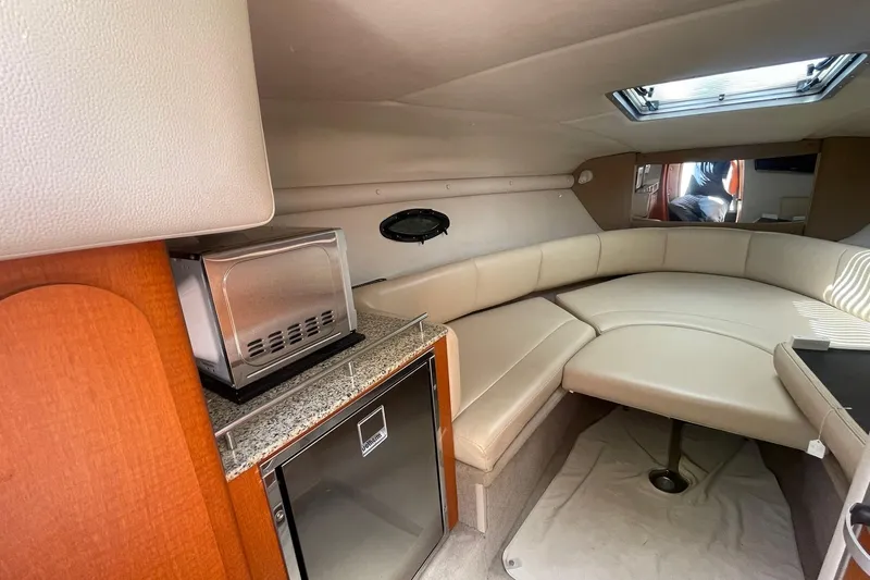 Slide: The Image of Interior of 2005 Chaparral 265 SSi boat with seating, kitchenette, and skylight. - 18