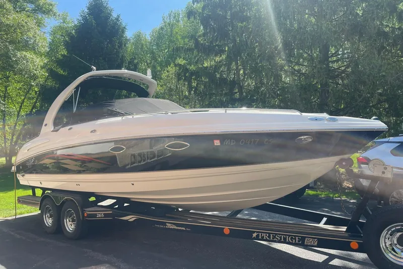 Slide: The Image of 2005 Chaparral 265 SSi boat on trailer, parked outdoors in a sunny, wooded area. - 2