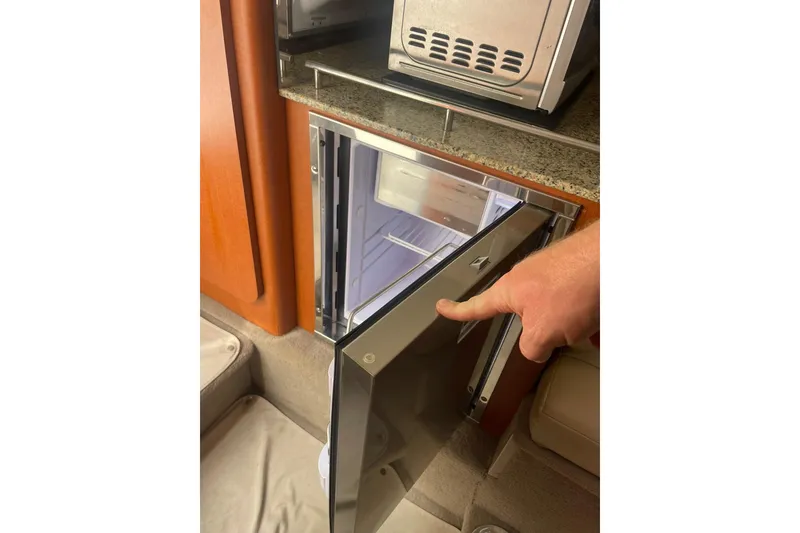 Slide: The Image of 2005 Chaparral 265 SSi boat interior with open mini fridge and microwave. - 20