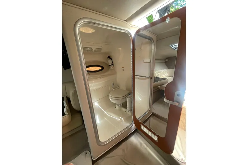 Slide: The Image of Interior of 2005 Chaparral 265 SSi boat featuring a compact bathroom with a toilet. - 22
