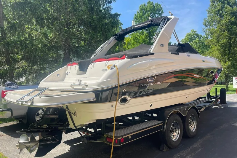Slide: The Image of 2005 Chaparral 265 SSi boat on trailer, parked outdoors with trees in background. - 3