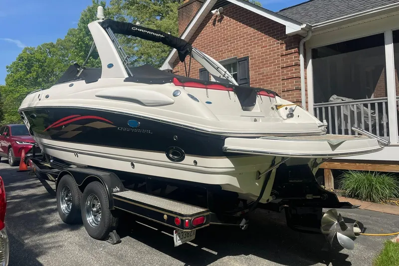 Slide: The Image of 2005 Chaparral 265 SSi boat on trailer, parked beside a brick house. - 4