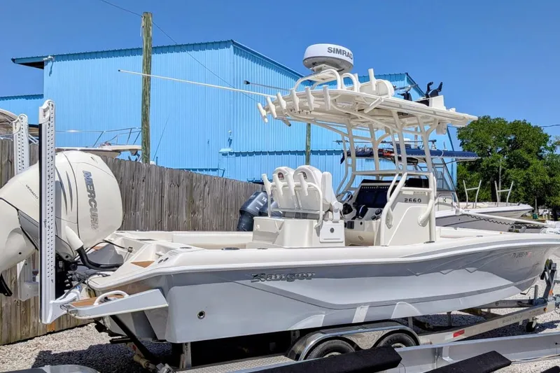 The Image of 2023 Ranger 2660 Bay boat with Mercury engine, parked outdoors on a trailer. - 1