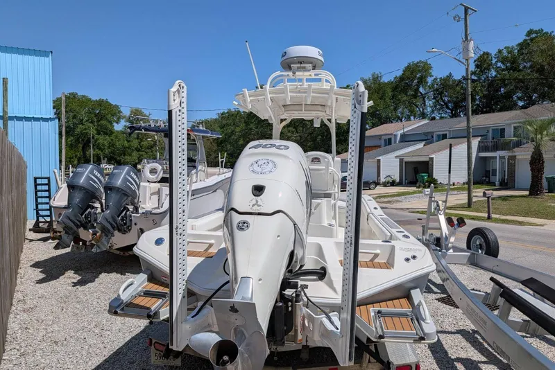 Slide: The Image of 2023 Ranger 2660 Bay boat with dual Yamaha engines, parked outdoors. - 4