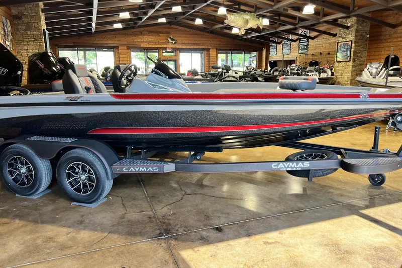 The Image of 2026 Caymas 201 Pro boat on trailer in showroom, featuring sleek design and modern features. - 1