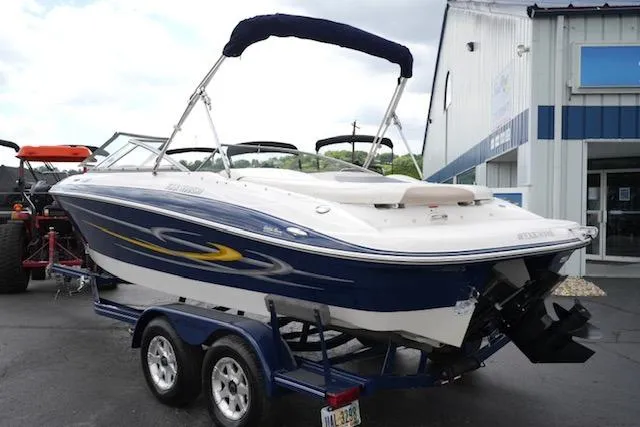 Slide: The Image of 2006 Four Winns 210 Horizon boat on trailer, parked outside a building. - 7